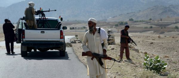 Afghan Local Police (ALP) keep watch along the road near a checkpoint, set alight by Islamic (IS) fighters during overnight clashes between Afghan forces and Islamic state (IS) groups, in Achin district of eastern Nangarhar province on September 28, 2015 - Sputnik International