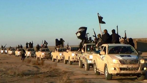 In this undated file photo released by a militant website, which has been verified and is consistent with other AP reporting, militants of the Islamic State group hold up their weapons and wave its flags on their vehicles in a convoy on a road leading to Iraq, while riding in Raqqa city in Syria - Sputnik International