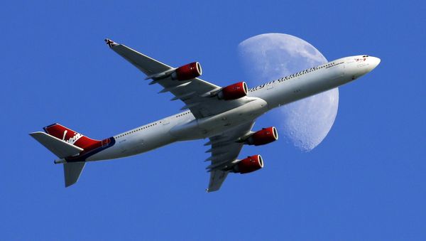 A Virgin Atlantic passenger plane crosses a waxing gibbous moon on its way to the Los Angeles International Airport, Sunday, Aug. 23, 2015, in Whittier, Calif - Sputnik International