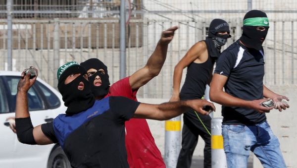 Palestinians hurl stones towards Israeli border police during clashes at a checkpoint between Shuafat refugee camp and Jerusalem September 18, 2015 - Sputnik International