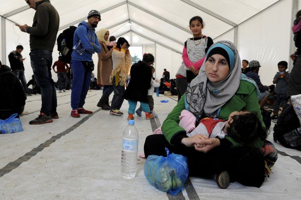 A migrant woman holds a baby inside a large tent set by NGOs, as refugees and migrants wait to cross Greece's border with Macedonia near the Greek village of Idomeni, September 26, 2015 A migrant woman holds a baby inside a large tent set by NGOs, as refugees and migrants wait to cross Greece's border with Macedonia near the Greek village of Idomeni, September 26, 2015 - Sputnik International