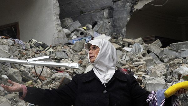 In this Wednesday, Feb. 6, 2013 photo, a Syrian woman stands amid the ruins of her house which was destroyed in an airstrike by government warplanes a few days earlier, killing 11 members of her family, in the neighborhood of Ansari, Aleppo, Syria. - Sputnik International