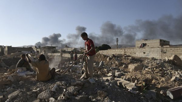 Children inspect rubble as smoke rises behind them during clashes between forces loyal to Syria's President Bashar al-Assad and the Army of Islam fighters, on the eastern mountains of Qalamoun overlooking the town of Douma, eastern Ghouta in Damascus September 19, 2015 - Sputnik International