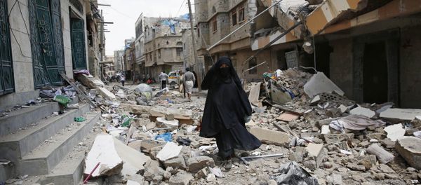 A woman walks amid the rubble of houses destroyed by a Saudi-led airstrike in Sanaa, Yemen, Monday, Sept. 21, 2015 - Sputnik International