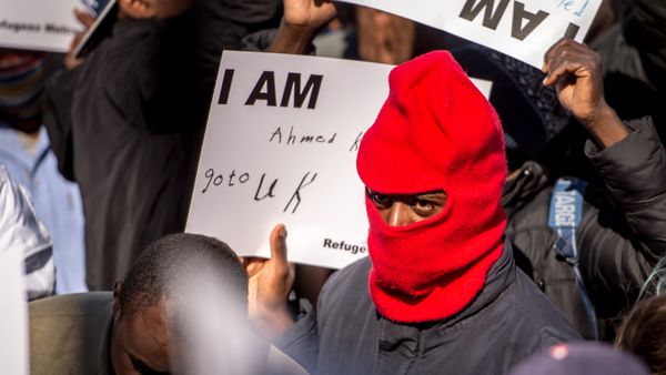 A migrant holds a placard reading 'I am Ahmed. Go to UK' as part of a rally of around 3000 migrants and members of associations aiding migrants including British associations, in the northern French port city of Calais (File) - Sputnik International