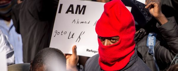 A migrant holds a placard reading 'I am Ahmed. Go to UK' as part of a rally of around 3000 migrants and members of associations aiding migrants including British associations, in the northern French port city of Calais, on September 19, 2015 A migrant holds a placard reading 'I am Ahmed. Go to UK' as part of a rally of around 3000 migrants and members of associations aiding migrants including British associations, in the northern French port city of Calais, on September 19, 2015 - Sputnik International