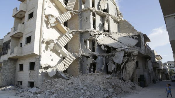 A girl walks near a damaged building in Maarat Al-Nouman, south of Idlib, Syria September 29, 2015. Picture taken September 29, 2015 - Sputnik International