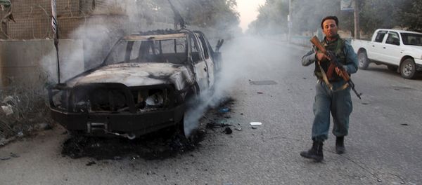 An Afghan policeman patrols next to a burning vehicle in the city of Kunduz, Afghanistan October 1, 2015 An Afghan policeman patrols next to a burning vehicle in the city of Kunduz, Afghanistan October 1, 2015 - Sputnik International