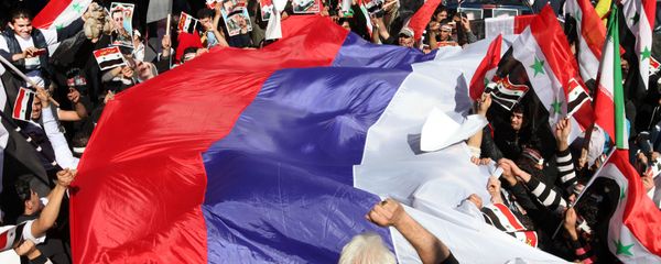 Pro-Syrian regime protesters wave a large Russian flag during a demonstration - Sputnik International