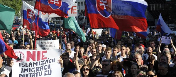 Participants hold flags and banners reading 'No Islamization, migration and dictatorship of the EU' during an anti-immigration rally organised by an initiative called Stop Islamisation of Europe and backed by the far-right People's Party-Our Slovakia on September 12, 2015 in Bratislava, Slovakia. Participants hold flags and banners reading 'No Islamization, migration and dictatorship of the EU' during an anti-immigration rally organised by an initiative called Stop Islamisation of Europe and backed by the far-right People's Party-Our Slovakia on September 12, 2015 in Bratislava, Slovakia. - Sputnik International