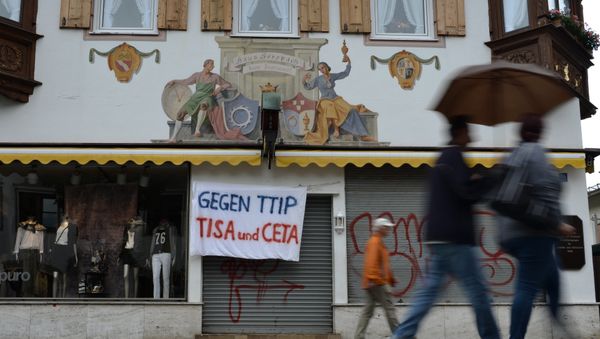 A banner reading 'Against TTIP, TiSA and CETA' hangs over the entrance of a shop in Garmisch-Partenkirchen, southern Germany A banner reading 'Against TTIP, TiSA and CETA' hangs over the entrance of a shop in Garmisch-Partenkirchen, southern Germany - Sputnik International