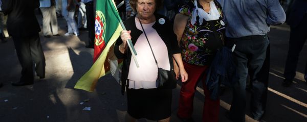A supporter of the Portuguese Socialist Party carries a Portuguese flag while waiting for the arrival of the party leader Antonio Costa during a campaign action in Lisbon Tuesday, Sept. 29 2015. A supporter of the Portuguese Socialist Party carries a Portuguese flag while waiting for the arrival of the party leader Antonio Costa during a campaign action in Lisbon Tuesday, Sept. 29 2015. - Sputnik International