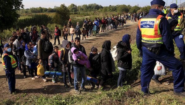 Migrants queue to board a train at the railway station in Zakany, Hungary October 1, 2015. - Sputnik International