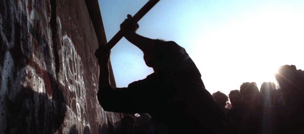 A man hammers away at the Berlin Wall on Nov. 12, 1989 as the border barrier between East and West Germany was torn down after 28 years, symbolically ending the Cold War. - Sputnik International