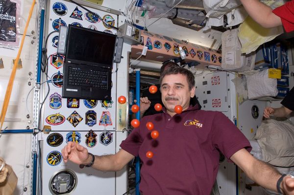 Cosmonaut Mikhail Kornienko near floating tomatoes in the Unity Node of the ISS. - Sputnik International