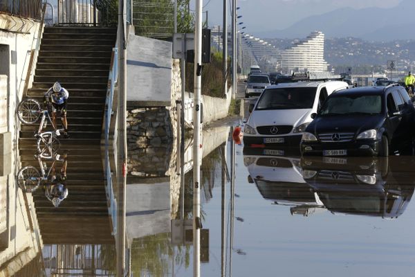 A man carrying his bicycle tries to make his way after floods in Biot, near Cannes, southeastern France - Sputnik International