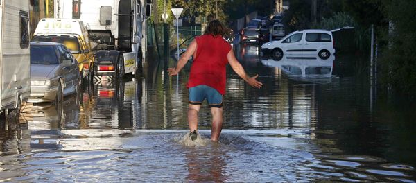 A man reacts as he wades through flood waters near cars after flooding caused by torrential rain in Biot, France A man reacts as he wades through flood waters near cars after flooding caused by torrential rain in Biot, France - Sputnik International