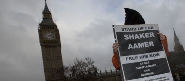 A hooded protester demonstrates for a Guantanamo detainee Shaker Aamer outside the Palace of Westminster in London, Wednesday, Jan. 15, 2014. - Sputnik International