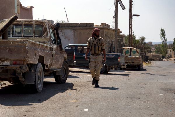 A Free Syrian Army fighter walks near military vehicles during what they said was preparations for an operation to strike at forces loyal to Syria's president Bashar Al-Assad in order to break a siege on the city of Beit Gin located in western countryside of Damascus in Deraa, Syria September 30, 2015 - Sputnik International