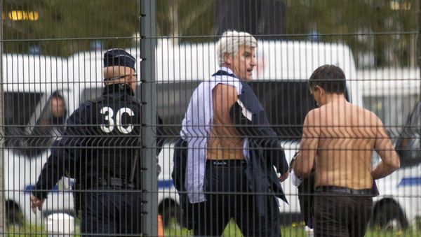 Air France director of Human Ressources, Xavier Broseta, right, and Air France assistant director long-haul flight, Pierre Plissonnier, center, are protected by a police officer as they flee the company headquarters at Roissy Airport, north of Paris, after scuffles with union activist, Monday, Oct. 5, 2015. Union activists protesting proposed layoffs at Air France stormed the headquarters during a meeting about the job cuts, zeroing in on two managers who had their shirts torn from their bodies, scaled a fence and fled under police protection. - Sputnik International