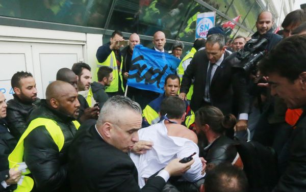 Air France director of Human Ressources, Xavier Broseta, center (back to the camera), protected by security guards tries to flee the Air France headquarters at Roissy Airport, north of Paris, France, during scuffles with union activists, Monday, Oct. 5, 2015. Union activists protesting proposed layoffs at Air France stormed the headquarters during a meeting about the job cuts, zeroing in on two managers who had their shirts torn from their bodies, scaled a fence and fled under police protection. Air France director of Human Ressources, Xavier Broseta, center (back to the camera), protected by security guards tries to flee the Air France headquarters at Roissy Airport, north of Paris, France, during scuffles with union activists, Monday, Oct. 5, 2015. Union activists protesting proposed layoffs at Air France stormed the headquarters during a meeting about the job cuts, zeroing in on two managers who had their shirts torn from their bodies, scaled a fence and fled under police protection. - Sputnik International