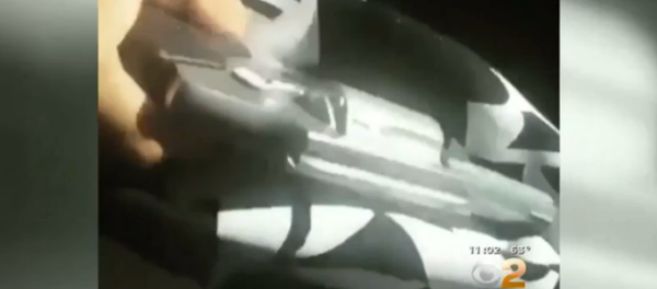 The video footage, posted on social media, begins with a Los Angeles police officer getting out of his patrol car, followed by a shot of a handgun held by a person watching the officer. The video footage, posted on social media, begins with a Los Angeles police officer getting out of his patrol car, followed by a shot of a handgun held by a person watching the officer. - Sputnik International