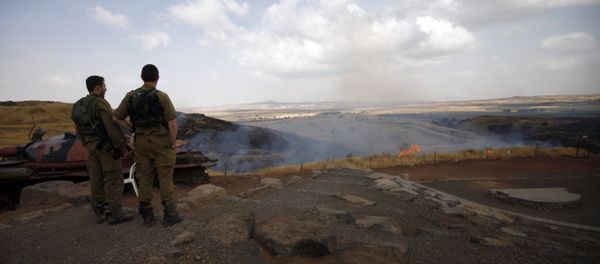 Israeli soldiers watch the flames on a mountain side in the El-Rom settlement in the Israeli-annexed Golan Heights on June 28, 2015 - Sputnik International