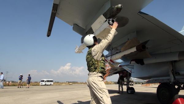 In this photo taken on Monday, Oct. 5, 2015, a Russian pilot fixes an air-to-air missile at his Su-30 jet fighter before a take off at Hmeimim airbase in Syria - Sputnik International
