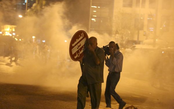 A protester and a cameraman (R) cover their faces as they are affected by tear gas fired by security forces in Martyr square, downtown Beirut, Lebanon October 8, 2015. Lebanese security forces fired tear gas and water cannons to break up an anti-government protest in Beirut on Thursday, and the country's fractious leaders postponed talks aimed at resolving a political crisis that is feeding public discontent. A protester and a cameraman (R) cover their faces as they are affected by tear gas fired by security forces in Martyr square, downtown Beirut, Lebanon October 8, 2015. Lebanese security forces fired tear gas and water cannons to break up an anti-government protest in Beirut on Thursday, and the country's fractious leaders postponed talks aimed at resolving a political crisis that is feeding public discontent. - Sputnik International