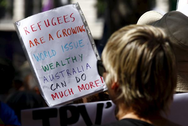 Protesters hold placards at the 'Stand up for Refugees' rally held in central Sydney. Australia is negotiating a deal with the Philippines to transfer asylum seekers being held indefinitely in controversial detention centres on remote, impoverished islands, Australia's immigration minister said on October 9, 2015 - Sputnik International