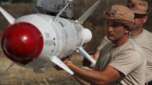 Russian servicemen attach a Kh-25 high-precision missile to a Su-24 aircraft at the Khmeimim airbase in Syria. - Sputnik International