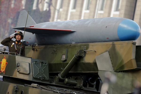 A soldier salutes from atop vehicle carrying a missile past a stand with North Korean leader Kim Jong Un during the parade celebrating the 70th anniversary of the founding of the ruling Workers' Party of Korea, in Pyongyang October 10, 2015 - Sputnik International