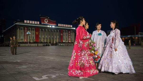 North Korean women wearing traditional 'hanbok' dresses stand on Kim Il-Sung square in Pyongyang on October 10, 2015 - Sputnik International