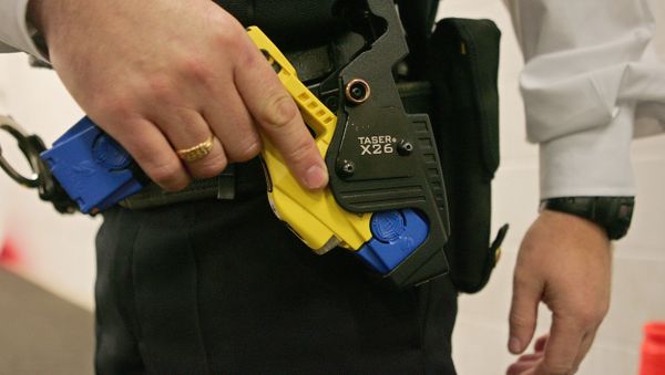 A file photo taken 05 December 2007 shows a British police officer holding a taser gun during a training session at the Metropolitan Police Specialist Training Centre, in Gravesend, Kent, in southeast England - Sputnik International