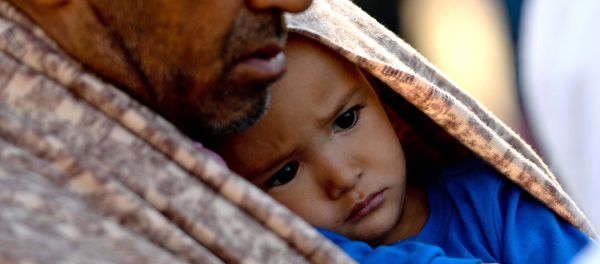 A migrant holds a child after their arrival at the railway station in Lehrte, near Hannover, northern Germany, Saturday, Oct. 3, 2015. A migrant holds a child after their arrival at the railway station in Lehrte, near Hannover, northern Germany, Saturday, Oct. 3, 2015. - Sputnik International