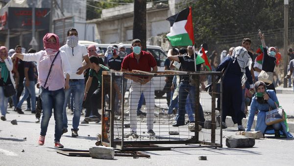 Palestinian protesters take up position during clashes with Israeli troops in the West Bank city of Hebron October 13, 2015 Palestinian protesters take up position during clashes with Israeli troops in the West Bank city of Hebron October 13, 2015 - Sputnik International
