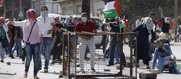 Palestinian protesters take up position during clashes with Israeli troops in the West Bank city of Hebron October 13, 2015 Palestinian protesters take up position during clashes with Israeli troops in the West Bank city of Hebron October 13, 2015 - Sputnik International