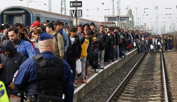 A Hungarian police officer watches as migrants arrive at the train station in Hegyeshalom, Hungary, October 6, 2015 - Sputnik International