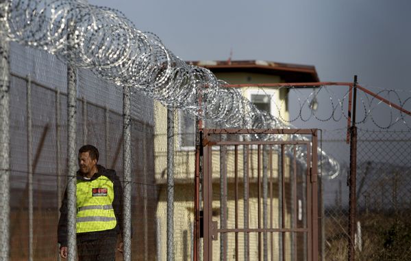 A security guard walks along a fence topped with barbed and razor wire in a facility for a detention of foreigners in the village of Drahonice, western Czech Republic, October 2, 2015.  - Sputnik International