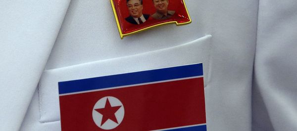 A pin of late North Korea leaders Kim Il Sung and Kim Jong Il and North Korea's flag are displayed on a North Korean reporter's jacket at the Main Media Center for the 17th Asian Games in Incheon, west of Seoul, South Korea - Sputnik International