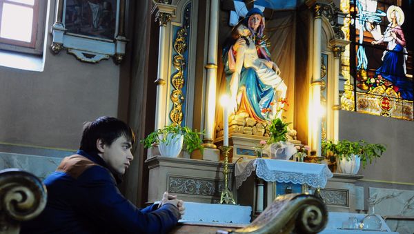 A man prays during a memorial mass for the victims of Kiev's fightings involving opposition activists at the St George Roman Catholic Church in the city of Uzhgorod, in the Transcarpathian region, western Ukraine, on March 1, 2014 - Sputnik International
