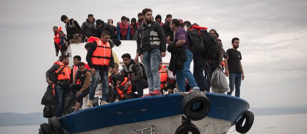 Migrants and refugees are seen aboard a Turkish fishing boat as they arrive on the Greek island of Lesbos after crossing a part of the Aegean Sea from the Turkish coast to Lesbos October 11, 2015 - Sputnik International