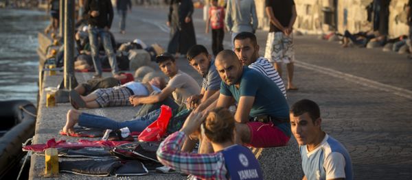 Migrants rest on an embankment of the port while waiting to be registered at the southeastern island of Kos, Greece, Wednesday, Aug. 19, 2015 Migrants rest on an embankment of the port while waiting to be registered at the southeastern island of Kos, Greece, Wednesday, Aug. 19, 2015 - Sputnik International