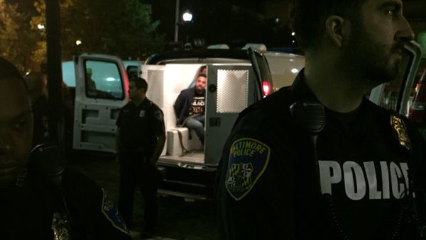 Police stand near vans holding protesters early Thursday, Oct. 15, 2015, in Baltimore - Sputnik International