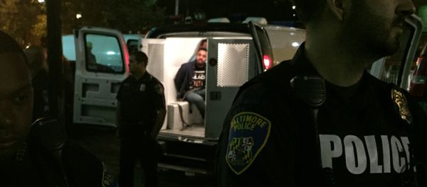 Police stand near vans holding protesters early Thursday, Oct. 15, 2015, in Baltimore Police stand near vans holding protesters early Thursday, Oct. 15, 2015, in Baltimore - Sputnik International
