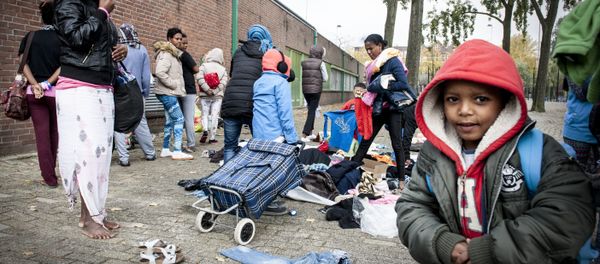 Refugees collect clothes, brought by residents of the neighborhood, outside the Schuttersveld Sports Centre designed as emergency shelter in Rotterdam, The Netherlands, on October 9, 2015 - Sputnik International