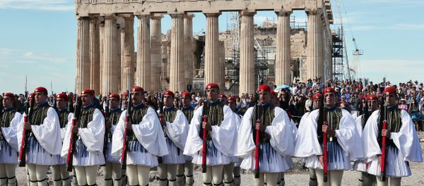 Greek Evzoni presidental guards attend the hoisting of the Greek flag ceremony atop the ancient Acropolis on October 12, 2015, marking the anniversary of the liberation of Athens from the German Nazi occupation in 1944. Greek Evzoni presidental guards attend the hoisting of the Greek flag ceremony atop the ancient Acropolis on October 12, 2015, marking the anniversary of the liberation of Athens from the German Nazi occupation in 1944. - Sputnik International
