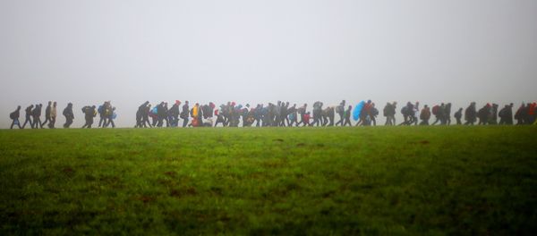 A group of migrants make their way over a meadow after crossing the border between Austria and Germany in Wegscheid near Passau, Germany, Thursday, Oct. 15, 2015. A group of migrants make their way over a meadow after crossing the border between Austria and Germany in Wegscheid near Passau, Germany, Thursday, Oct. 15, 2015. - Sputnik International