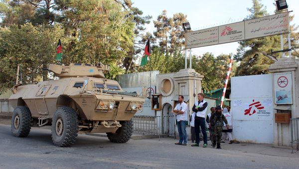 Christopher Stokes, second left, the general director of Doctors Without Borders and his colleague stand as an Afghan National Army vehicle guards at the gate of its hospital after U.S. troops left the area in Kunduz, Afghanistan, Thursday, Oct. 15, 2015. - Sputnik International