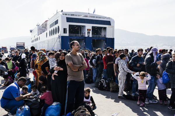 Refugees and migrants line up to board a ferry after arriving on the Greek island of Lesbos on October 16, 2015 - Sputnik International